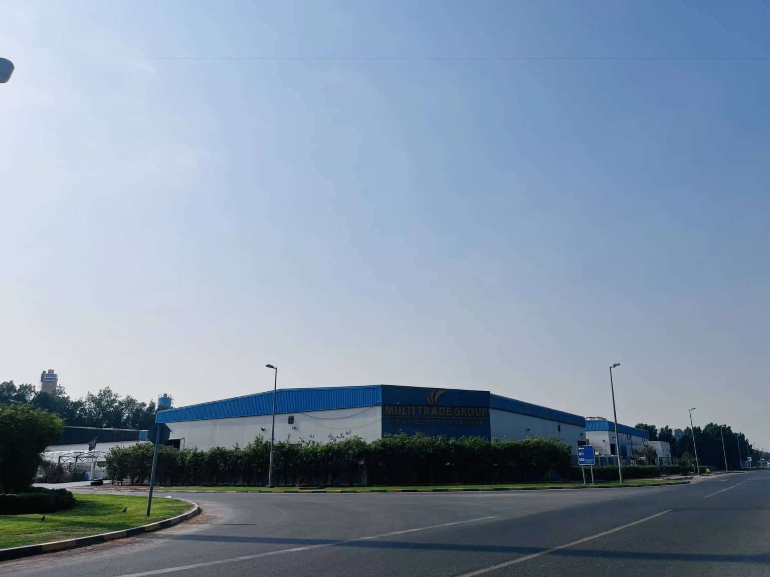 Exterior of Multi Trade Group's UAE warehouse building with blue roof and company signage